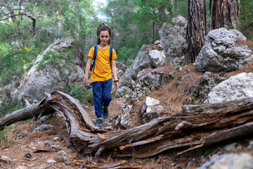 Adventure and travel. A boy with a backpack stands on a forest path. trips with children.