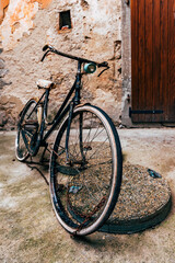 Abandoned vintage black bicycle at street of old town of Lovran in Croatia