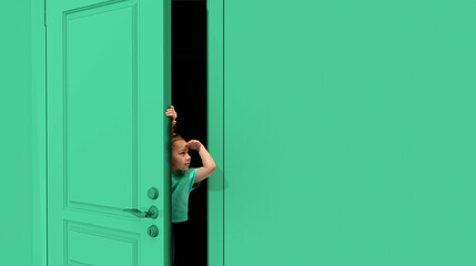 Little cute girl, kid peeking out green door with and to forehead. Playful mood, having fun. Curious kid looking with attention. Concept of childhood, emotions, facial expression, lifestyle