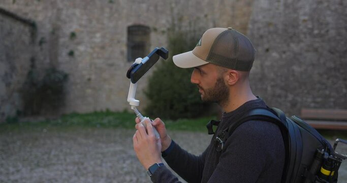 A videographer filming with a phone attached to Insta 360 Flow | AI-Powered Smartphone Stabilizer