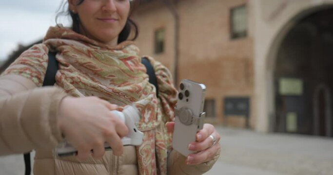 A female videographer attaching a phone to Insta 360 Flow in an old place | AI-Powered Smartphone Stabilizer