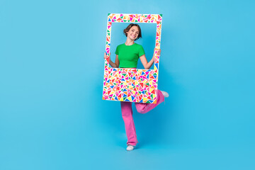 Full length photo of excited funny lady wear green t-shirt holding colorful photo frame isolated...