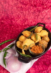 Indian Tea time snacks in group includes Veg Samosa, Kachori/kachaudi, aloo bonda, khaman dhokla, bread, onion,chilli and moong pakora/pakoda/bhaji/bhajji/Bhajiya/bajji with sauces, selective focus