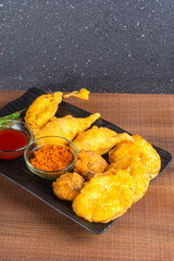 Indian Tea time snacks in group includes Veg Samosa, Kachori/kachaudi, aloo bonda, khaman dhokla, bread, onion,chilli and moong pakora/pakoda/bhaji/bhajji/Bhajiya/bajji with sauces, selective focus
