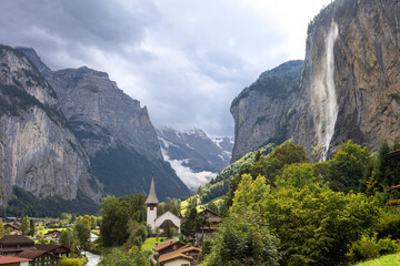 Lauterbrunnen valley elevated scenic view in switzerland with waterfall and dark clouds in late summer