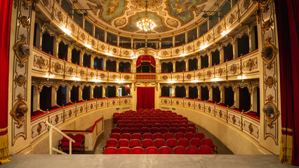 Wide shot of an Empty Elegant Classic Theatre with Red Velvet Chairs and Curtains. Well-lit Opera...