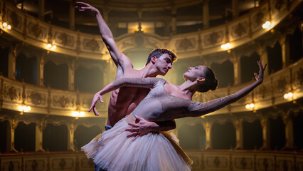Close Up shot of Two Young Classical Ballet Dancers Performing on Stage of Classic Theatre with Dramatic Lighting. Male and Female Performers Rehearse their Choreography Together Before the show