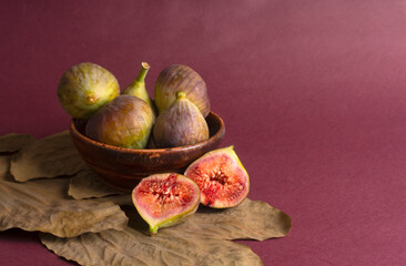 Freshly ripe figs. Healthy Mediterranean fig fruit. Fresh figs on a dark background. Beautiful blue violet figs with leaves, copy space, closeup