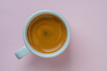 White porcelain espresso coffee cup over pink background, top view, copy space, closeup. Hot coffee...