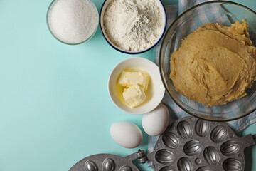 Ingredients for homemade walnut shaped cookies, dough and baking mold on turquoise table, flat lay. Space for text