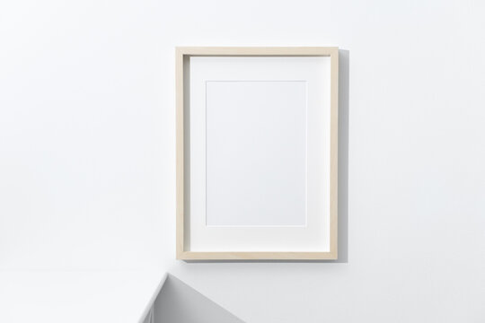 Blank wooden artwork frame mockup on white wall with copy space