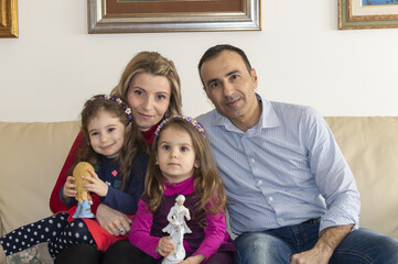 Ritratto di famiglia con padre, madre e le figlie gemelle di tre anni.
