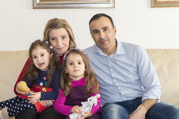 Ritratto di famiglia con padre, madre e le figlie gemelle di tre anni.