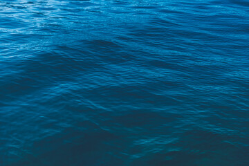 Fototapeta na wymiar Abstract natural background. Azure sea water with ripples on the surface. Сopy space, shot from top