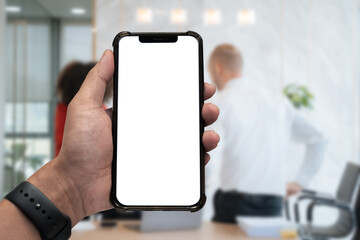 Business - technology and office concept - Hand holding mobile phone with blank screen in office.
