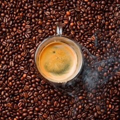 A cup of freshly brewed hot espresso coffee. roasted coffee bean background, top view. Free space for text.