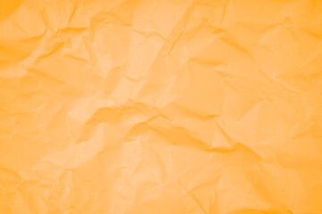 The abstract background from crumpled orange color paper texture.