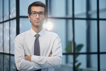 Satisfaction Survey Concept A confident business man with his arms crossed in front of an office building background