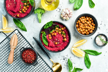 Red hummus from beets and chickpeas in a bowl. Vegan recipes based on plant foods. On a concrete...