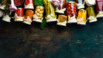 Vegetables in jars. Salting various vegetables in glass jars for long-term storage. On a stone background. Top view.