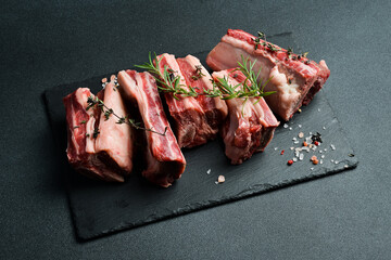 Raw sliced veal short spare loin ribs on a marble board. Black background. Top view. Copy space