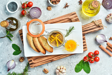 Liver pate. Pate with toast in a glass jar. On a white plate. On a gray stone background. Restaurant menu.