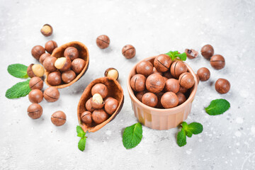 Macadamia nut. Macadamia nuts in a shell, in a bowl. On a stone background. Macadamia nuts are rich in various trace elements and vitamins.
