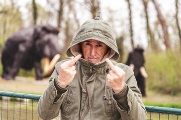 (Più valori)portrait of expressive middle aged man posing in front of dinosaur models in a...