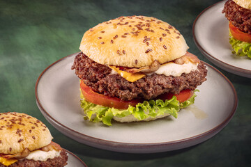 Hamburguesa a la parrilla sobre un plato y una mesa color verde
