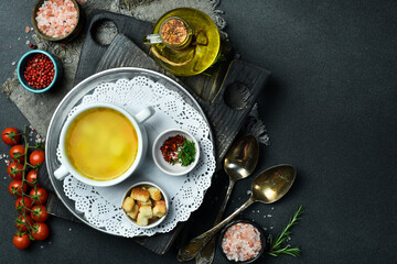 Chicken soup in a white bowl. Close-up, dark background.