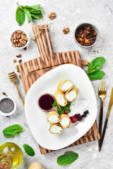 Dessert. Pancakes with cheese, berries and jam. On a white plate. On a gray stone background. Restaurant menu.