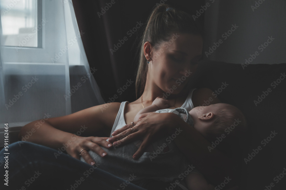 Wall mural cute newborn baby sleeping on hands loving happy mother at home, toned image. mom with kid together 