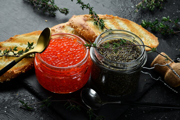 Set of red and black caviar in bowls. Premium caviar of high quality. On a black stone background....