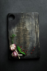 Vintage old Cutting Board, rosemary and spices. On a dark background. Free space for a menu recipe.