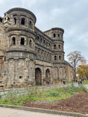 Fototapeta premium Trier, Germany, November 27, 2022: The Porta Nigra, the emblem of Trier (Germany's oldest city), is the best-preserved Roman city gate north of the Alps. The city gate was built around 170 CE.
