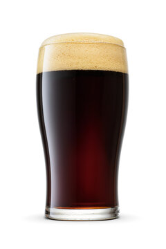 Tulip pint glass of fresh dark stout beer with cap of foam isolated on white background.