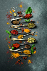 A set of colored spices in spoons. Cooking. Vertical photo. Top view.