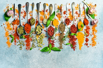 Banner of colored spices. Spoons with spices on a light stone background. Top view. Free space for text.