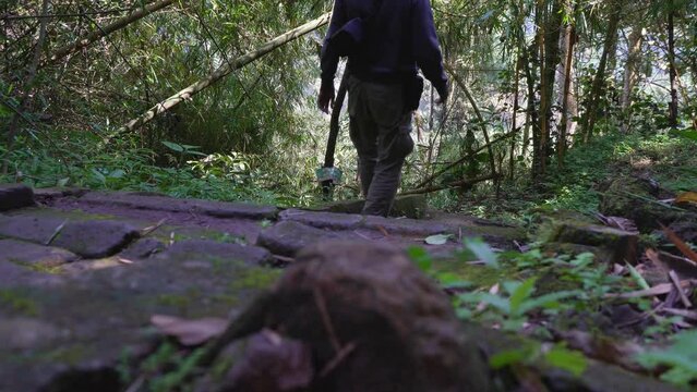 The man walking on the tropical forest for hiking mountain, to the travel destination on Semarang Central Java. The photo is suitable to use for adventure content media, nature footage.