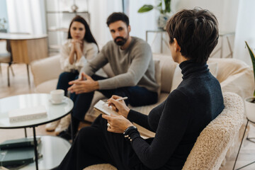 Couple having conversation with psychologist during therapy session