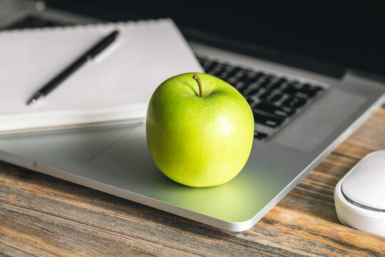 Apple Near Laptop At Workplace, Healthy Snack.