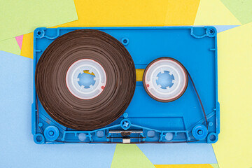 Top view of old vintage retro audio tape cassettes with a background of multicolored paper sticky...