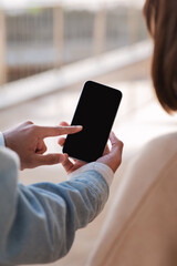 Young indian man showing smartphone with empty screen to caucasian female tourist
