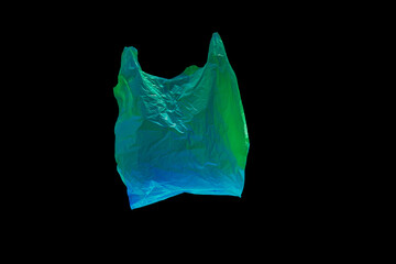 colored green and blue plastic bag fly on black background