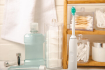 Modern sonic or electric toothbrush with charger in the bathroom. The concept of professional oral care and healthy teeth. Place for text. Close-up. Minimal design. Fresh breath. Healthy teeth.