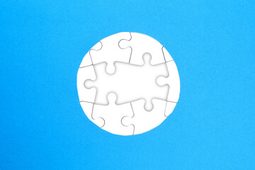 Frame of white puzzles on blue background. Place for your text. Mockup