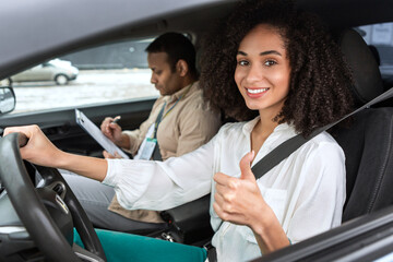 Middle Eastern Female Driver Gesturing Thumbs Up Sitting In Car