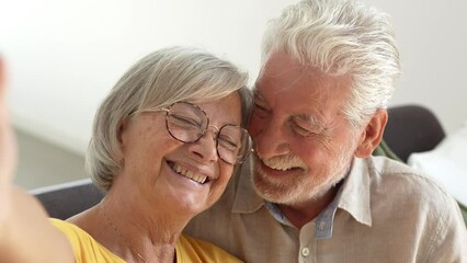 Head shot portrait happy senior couple taking selfie, having fun with phone cam, smiling aged wife and husband hugging, looking at camera, posing for photo, aged man vlogger recording video
