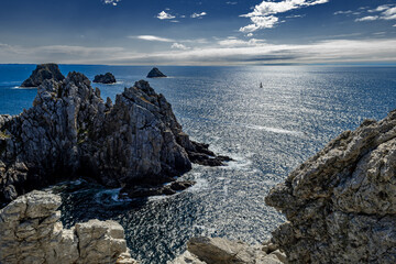 Cliffs And Sail Boat At Pointe De Penhir At The Finistere Atlantic Coast in Brittany, France
