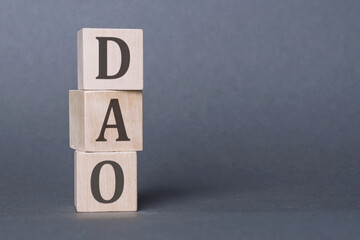 DAO characters. Decentralized autonomous organization. Written on three wooden blocks.